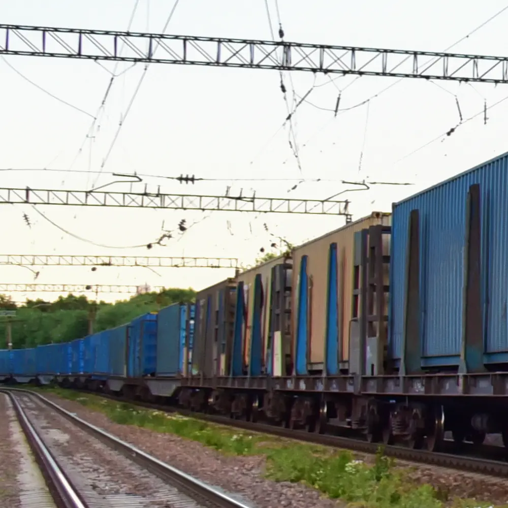 Cargo Containers Transportation On Freight Train By Railway. Intermodal Container On Train Car. Rail Freight Shipping Logistics Concept. Soft focus, possible granularity. Object in motion